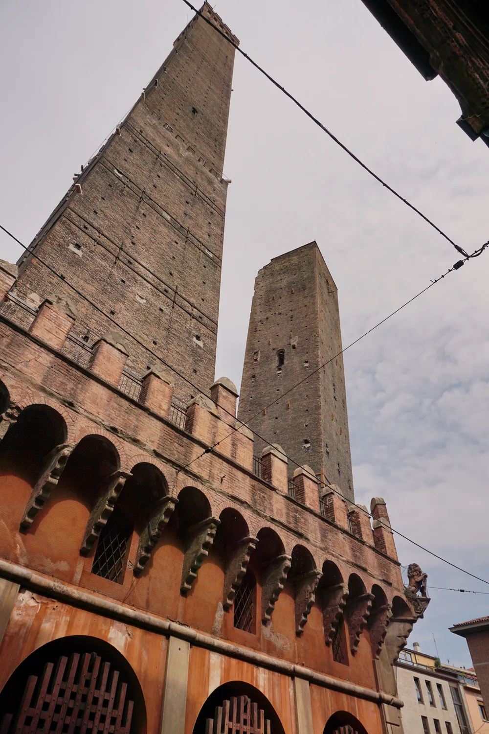 Le torri Asinelli e Garisenda viste dal basso, sopra gli edifici color terracotta di Bologna.